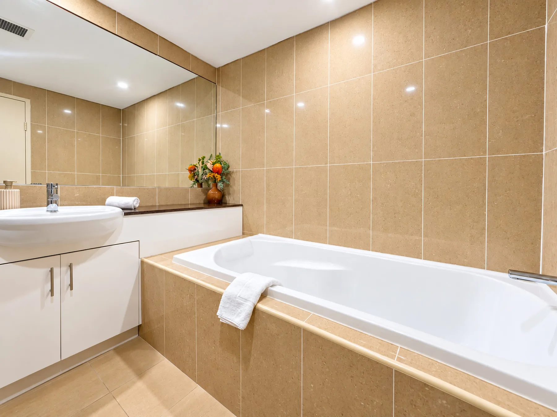 A tiled bathroom with a bathtub and sink.