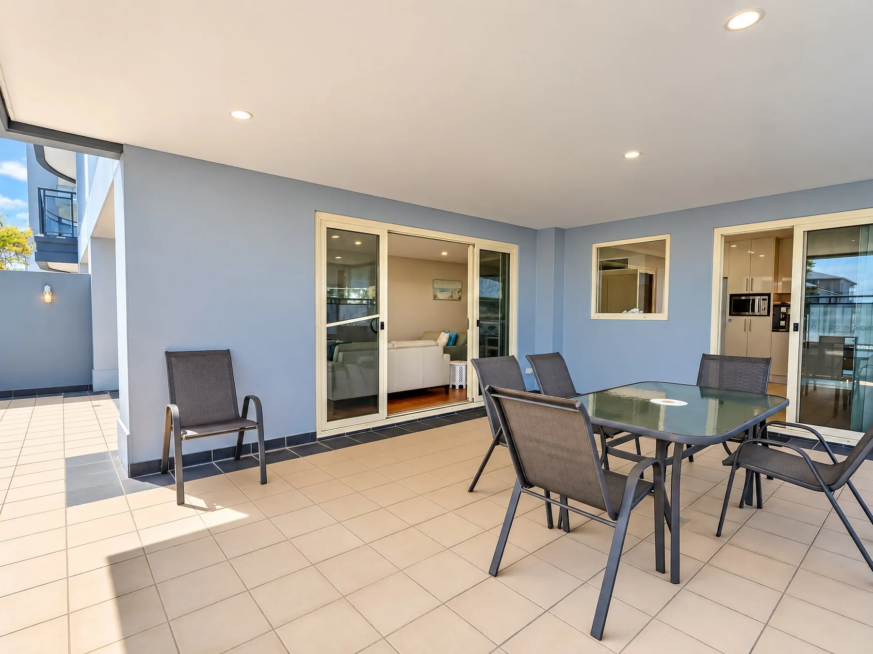 A tiled patio with outdoor seating and sliding glass doors.