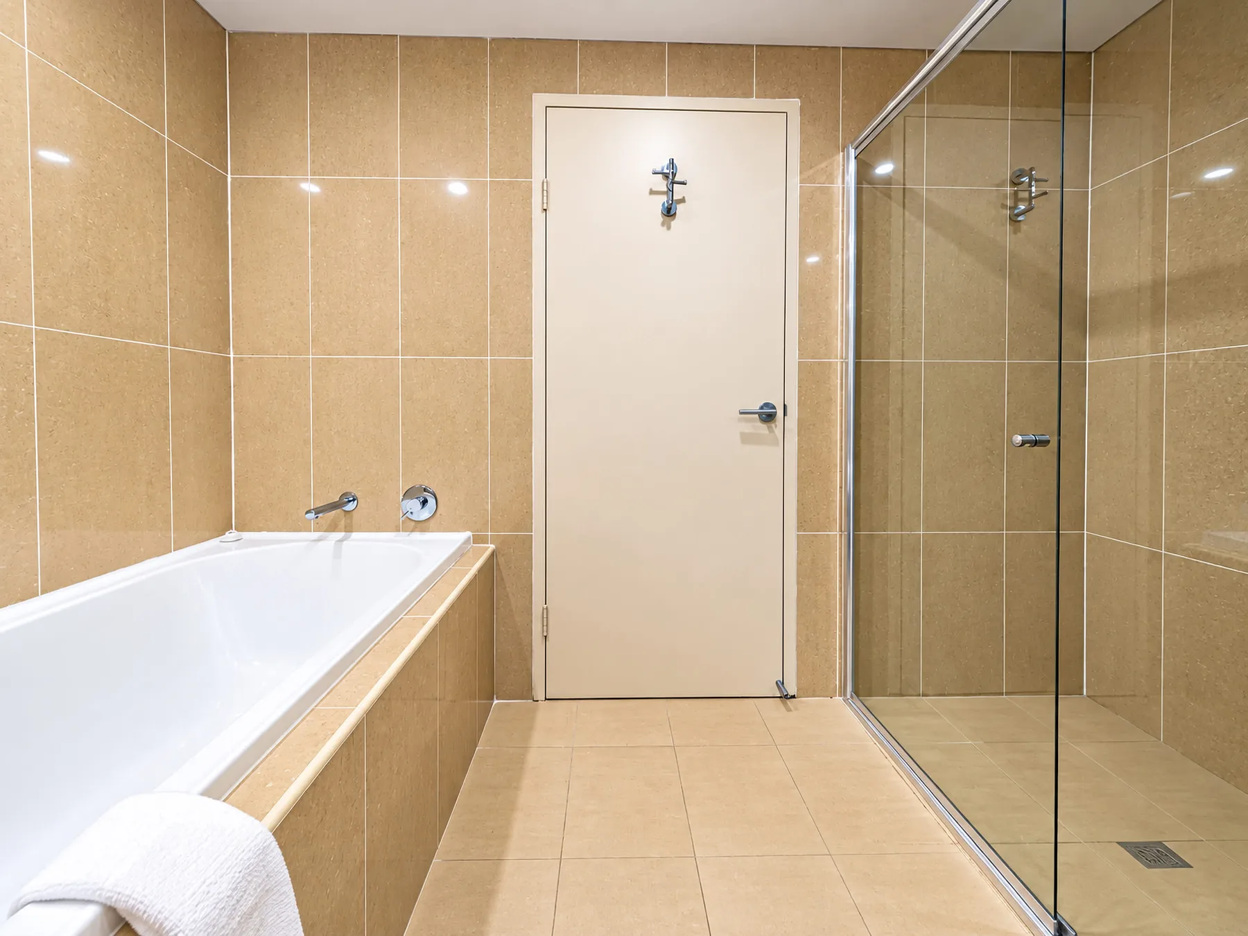 A tiled bathroom with a bathtub and glass shower.
