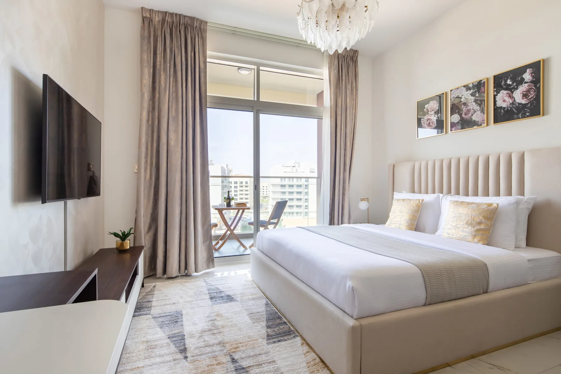 A bright bedroom with a neatly made bed beside a large window.