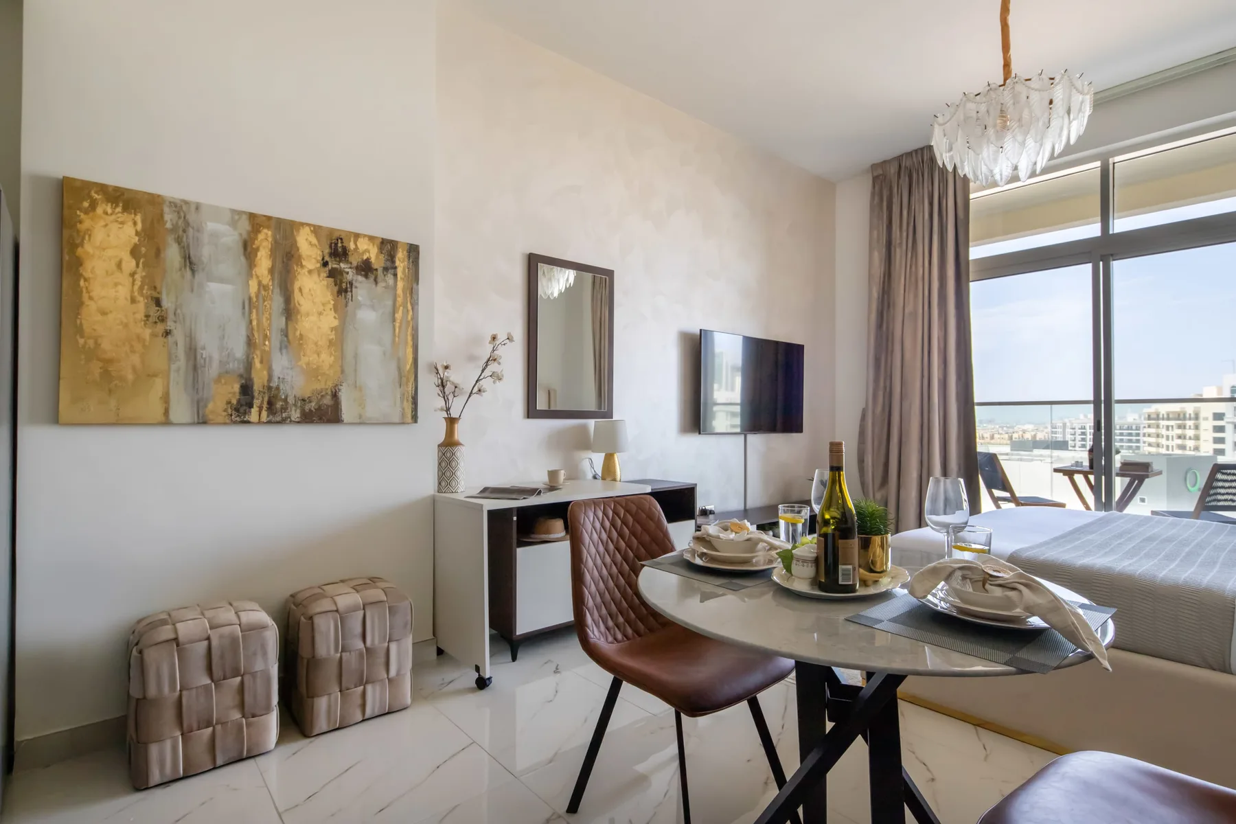 A bright bedroom with a dining table beside a large window.