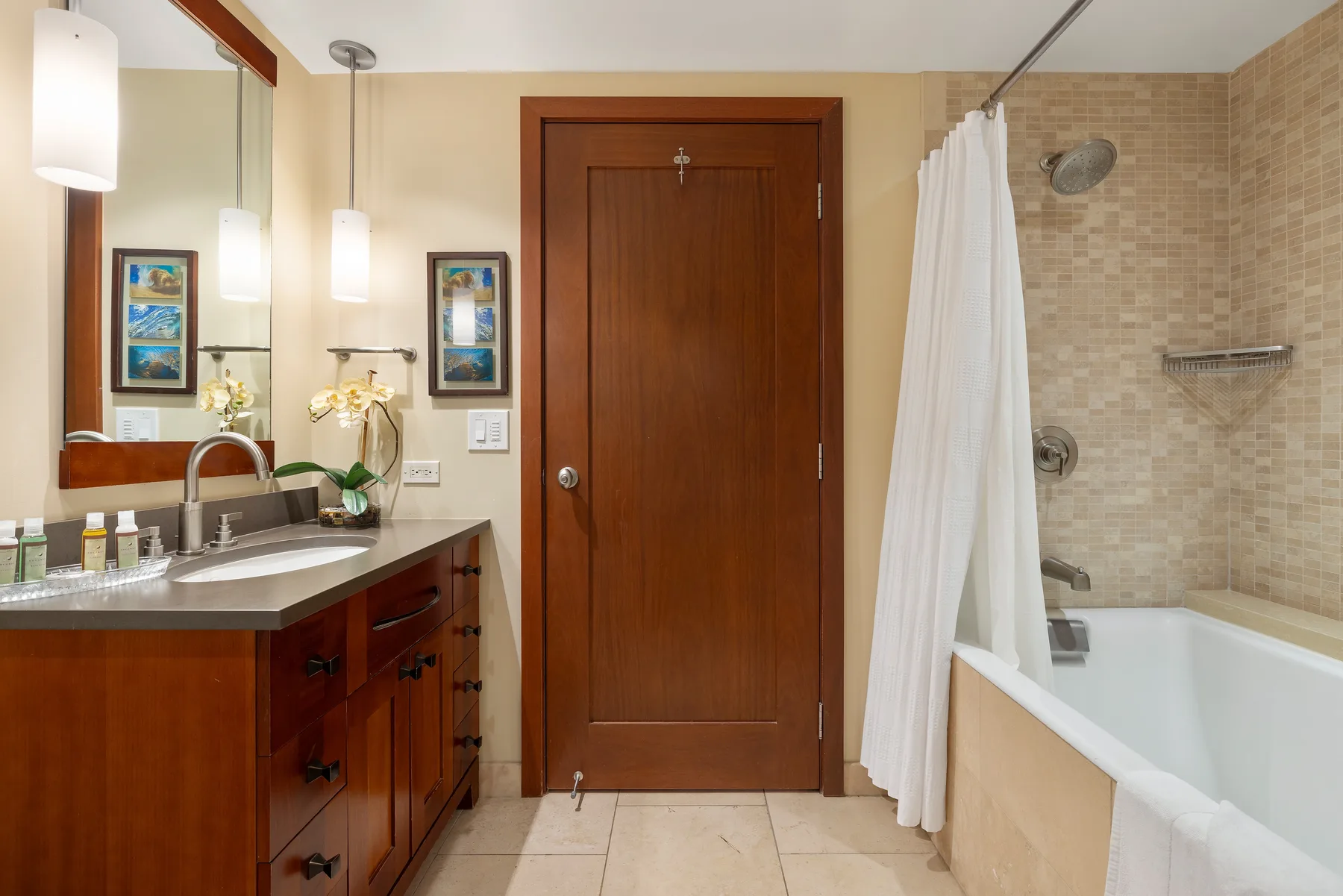 Un baño con un lavabo junto a una bañera y una cortina de ducha.