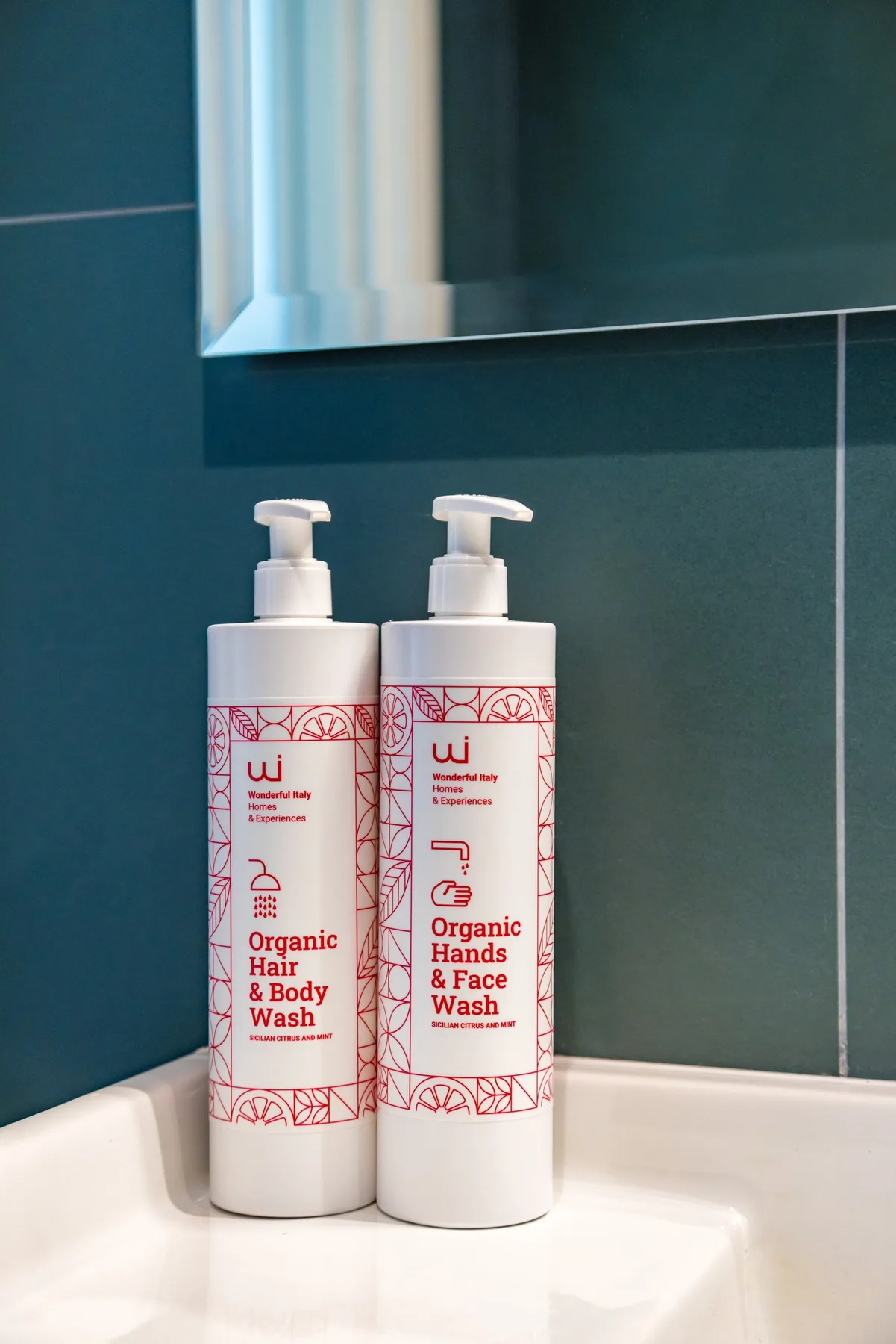 Productos de baño sobre un lavabo blanco, frente a una pared de azulejos.