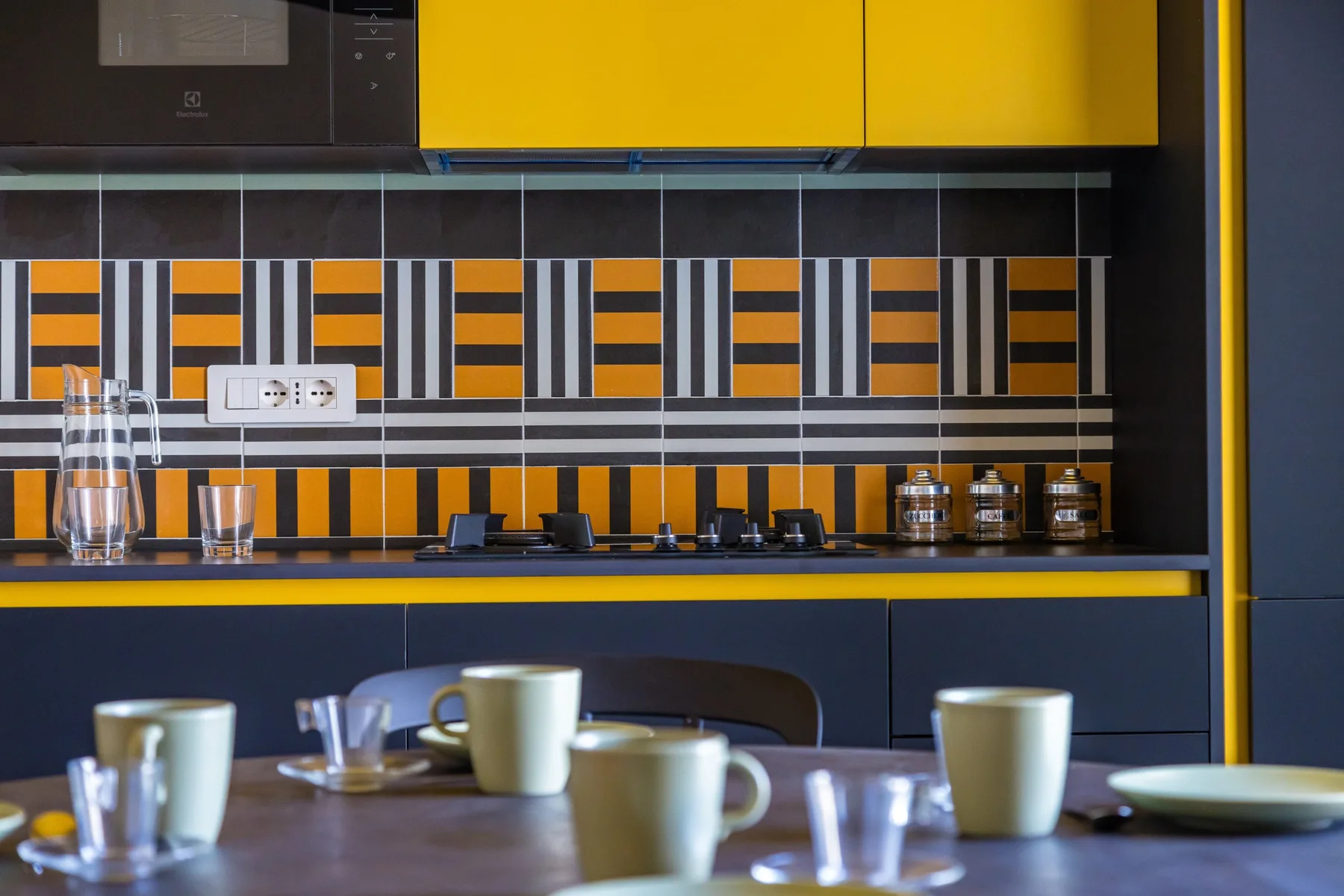 Una cocina moderna con gabinetes amarillos y un salpicadero estampado.