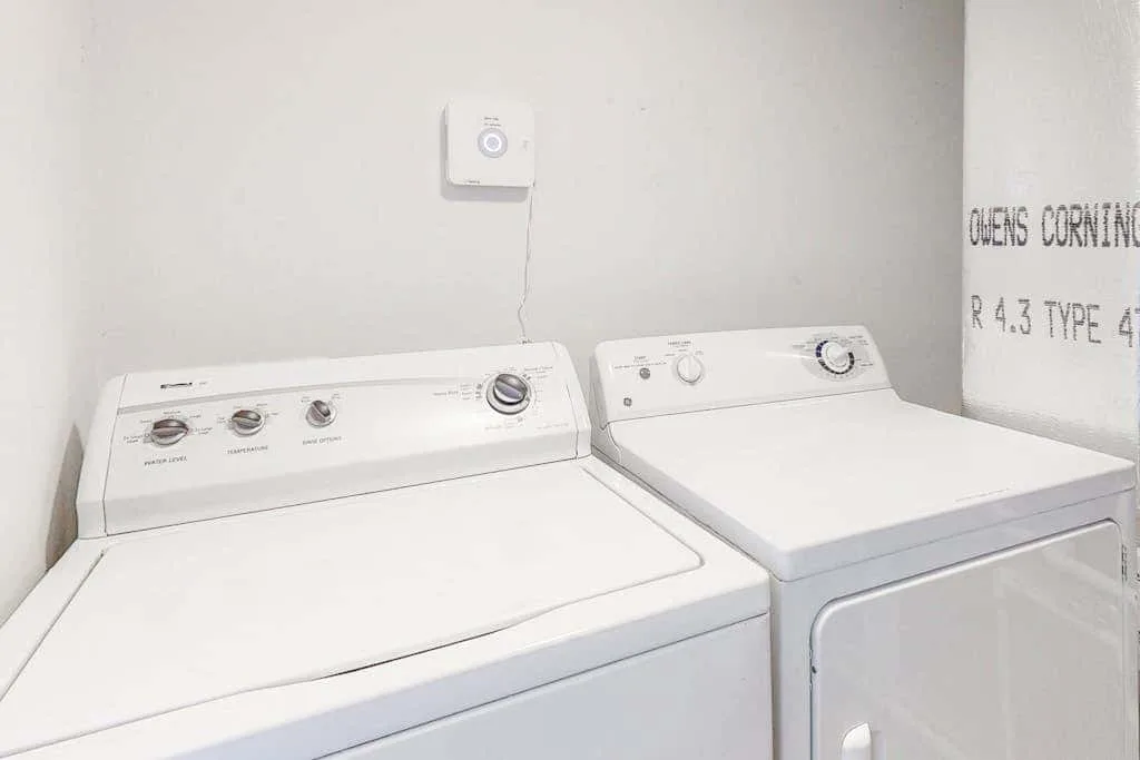 A laundry area with a top-loading washer and a front-loading dryer.