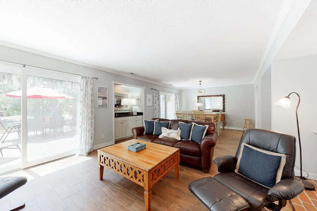 Living room with seating, a wooden coffee table, and sliding glass doors to a patio.