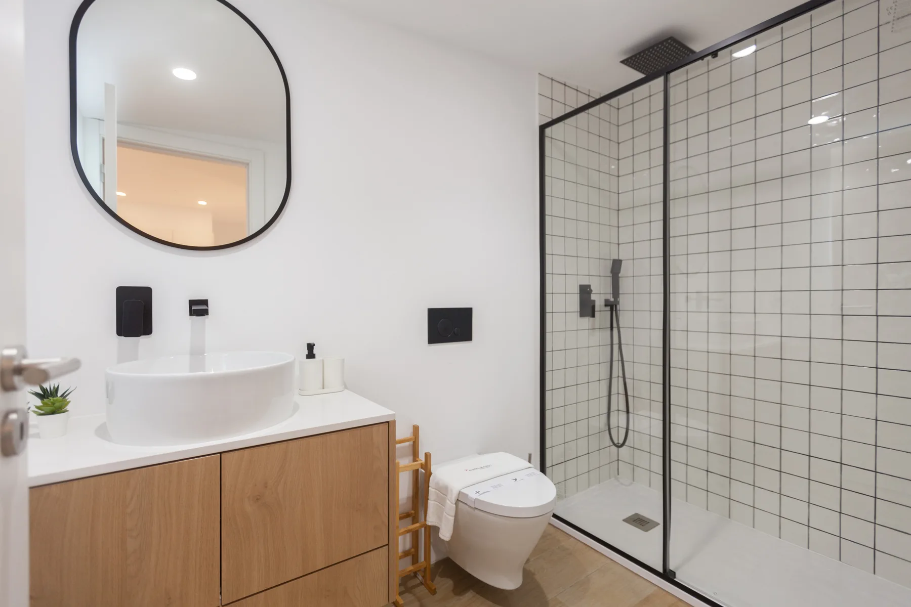 A modern bathroom with a vessel sink and glass-enclosed shower.