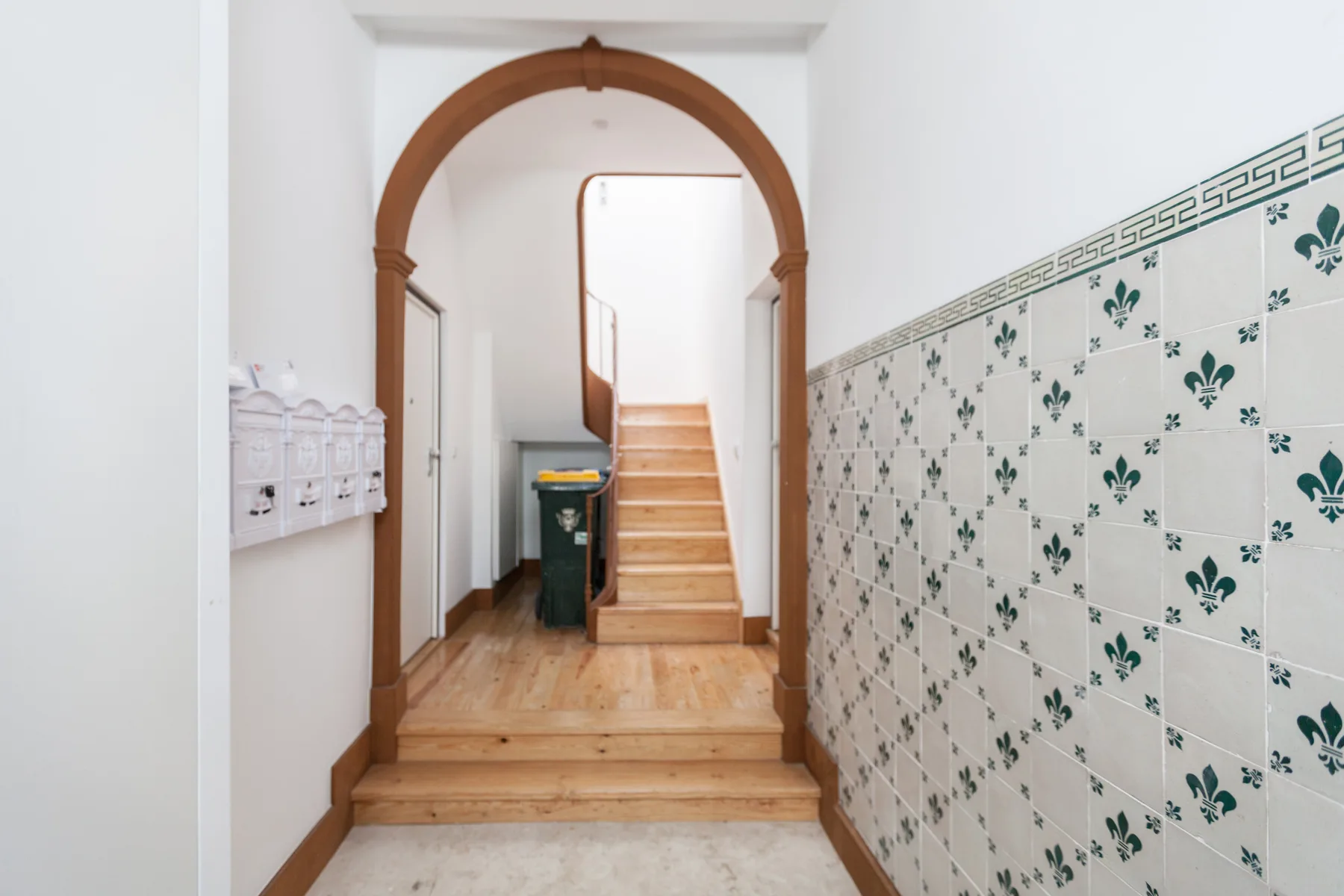 Un pasillo interior con azulejos decorados y escaleras de madera.