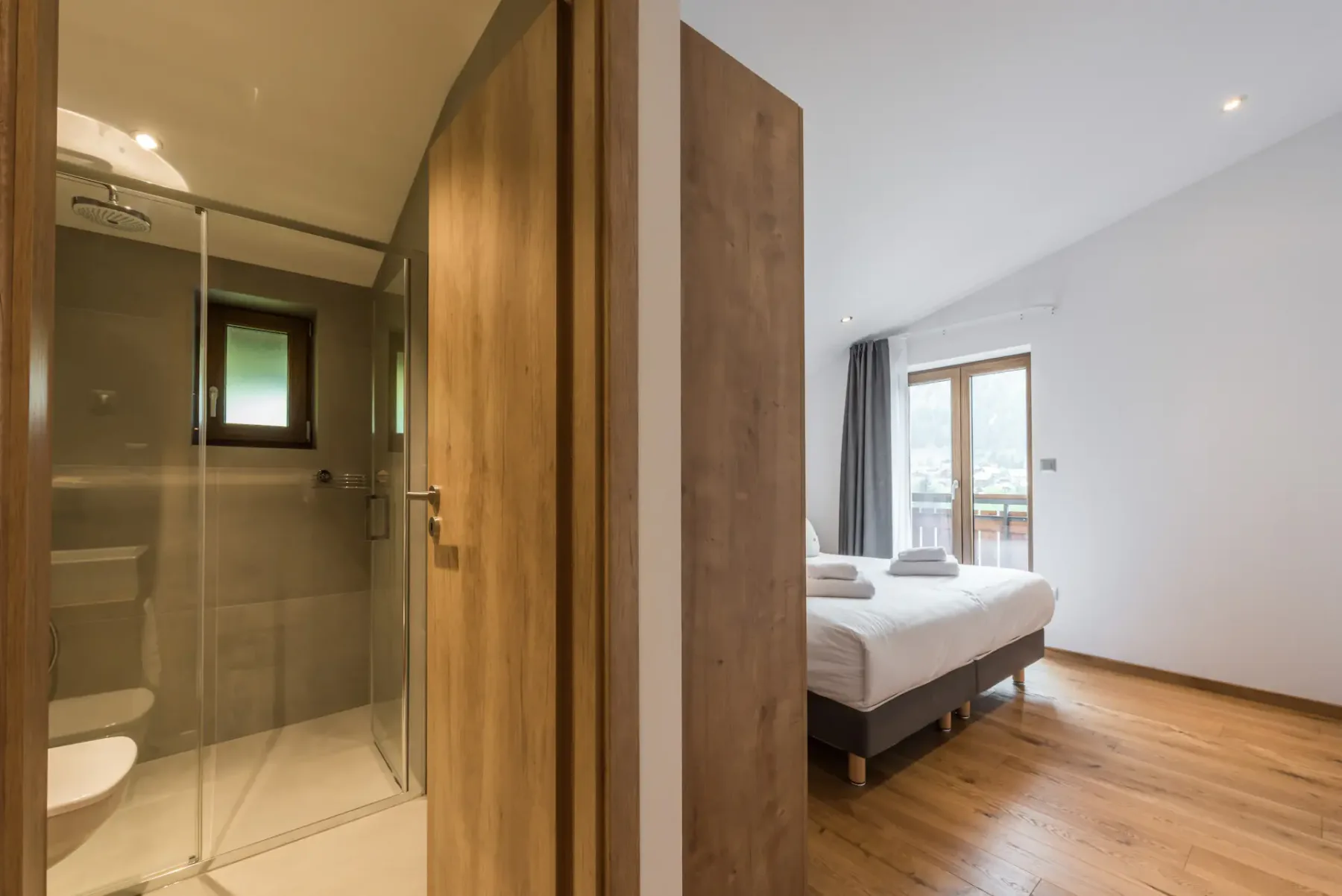 A bedroom with an adjoining bathroom is visible through the open doorway.