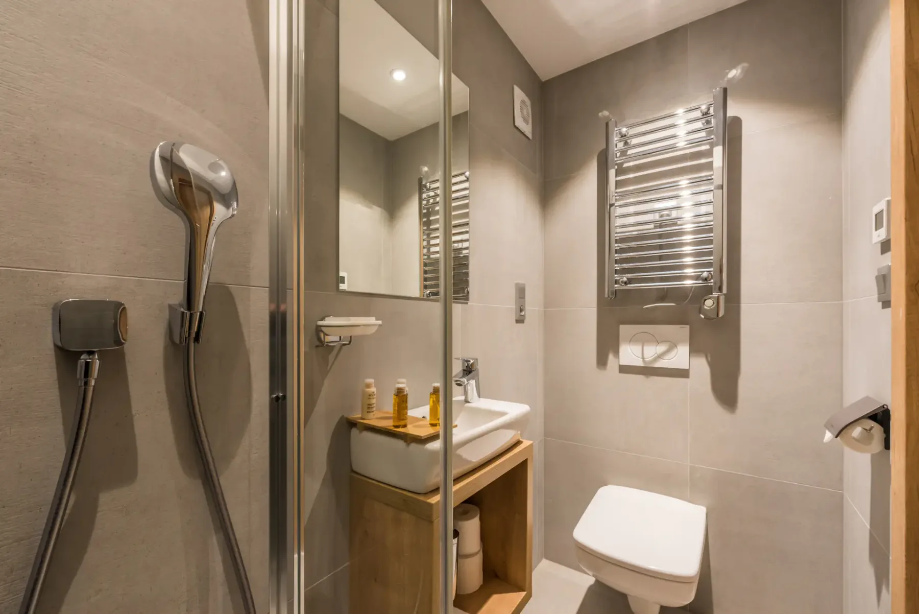 A modern bathroom with a shower, sink, and toilet.