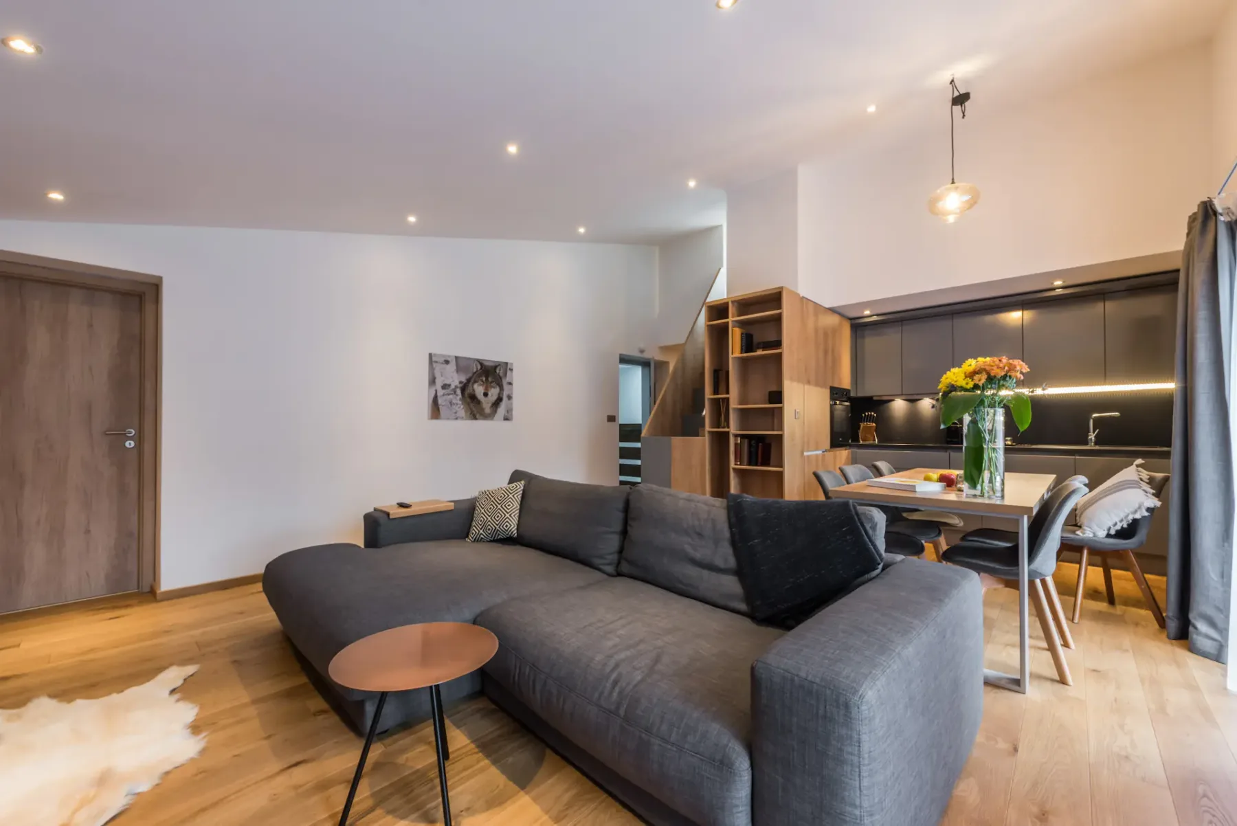 Living area with a sectional seating area and an open kitchen.