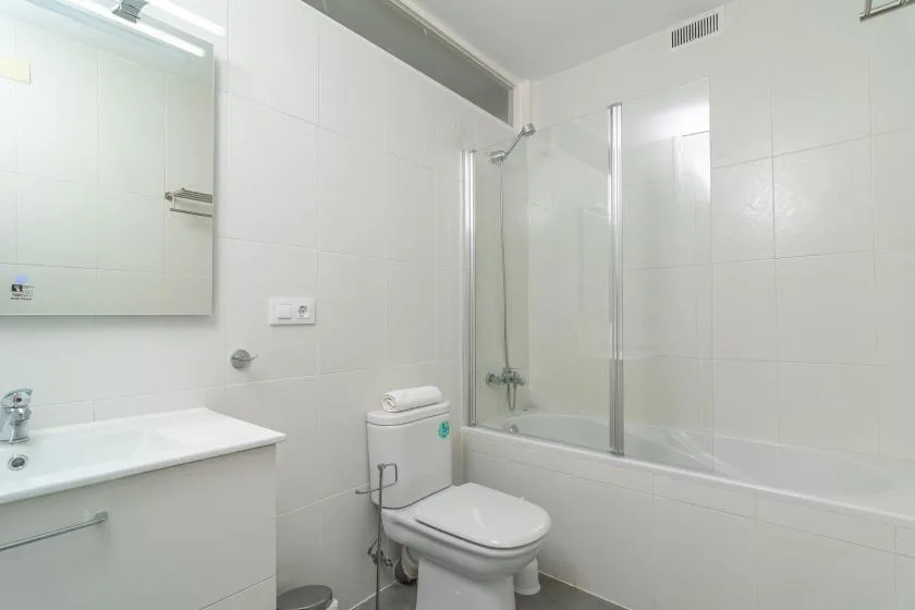 A tiled bathroom with a bathtub, shower, toilet, and sink.