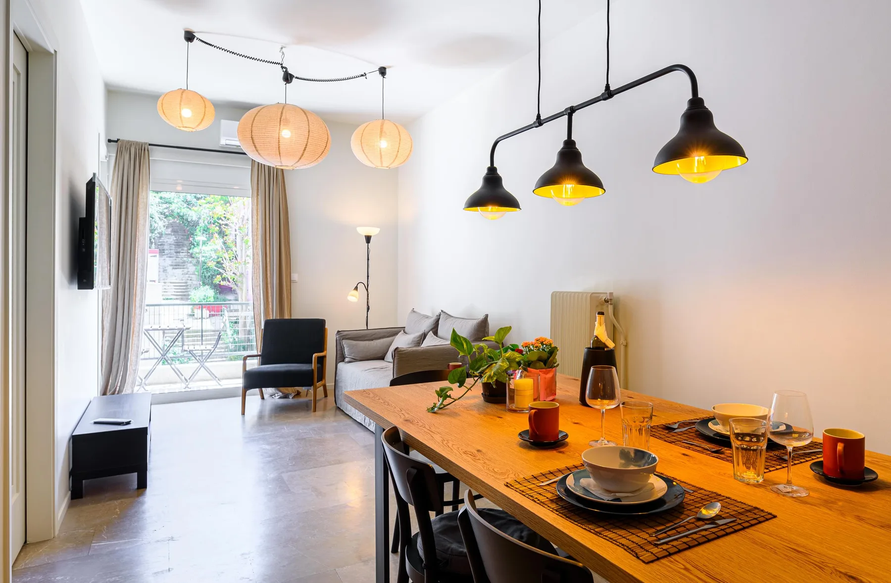 Un comedor con una mesa de madera se abre a una luminosa zona de estar.