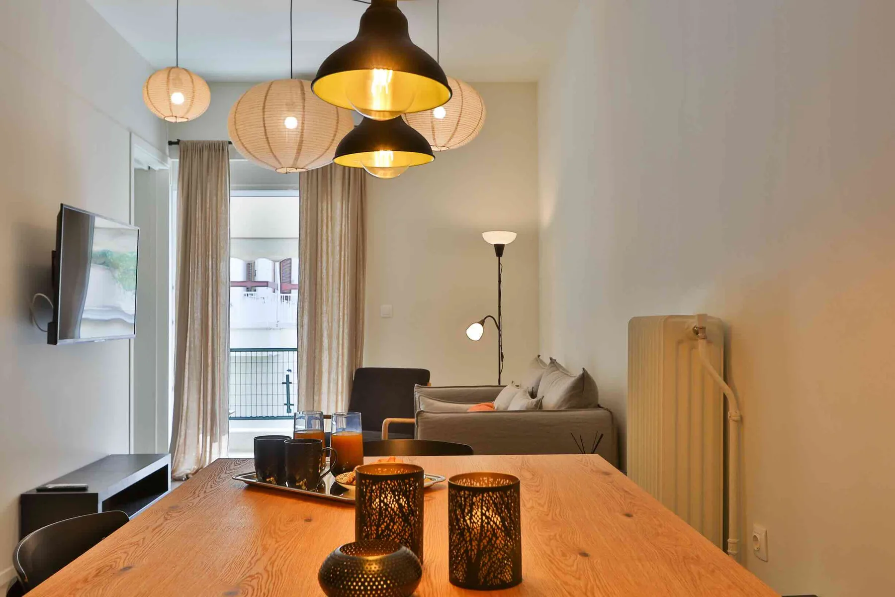 Zona de comedor y sala de estar con una mesa de madera y asientos.
