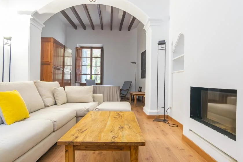 A bright living room with a sectional seating area and wooden coffee table.