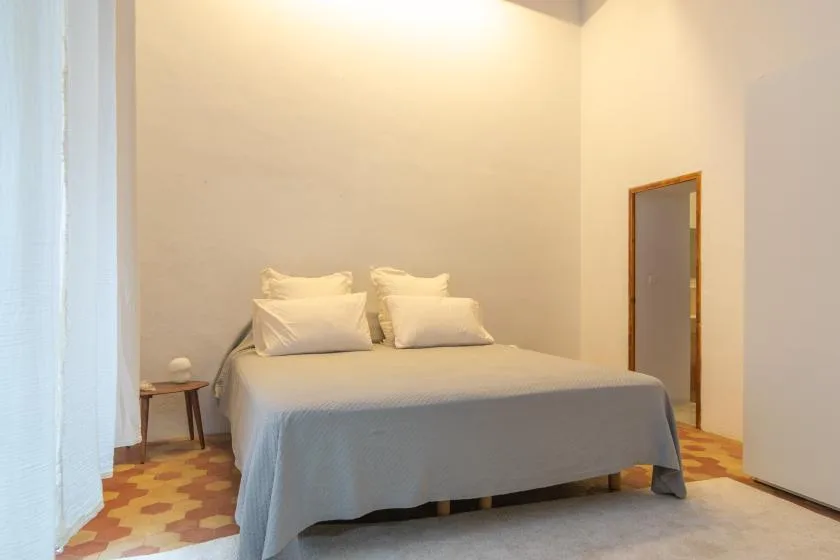 A bedroom with a bed and bedside table.