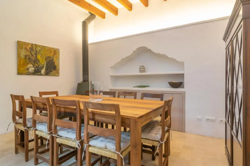 A dining area with a long wooden table and built-in wall shelving.