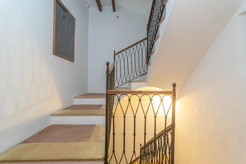 An interior staircase with decorative railings and light-colored steps.