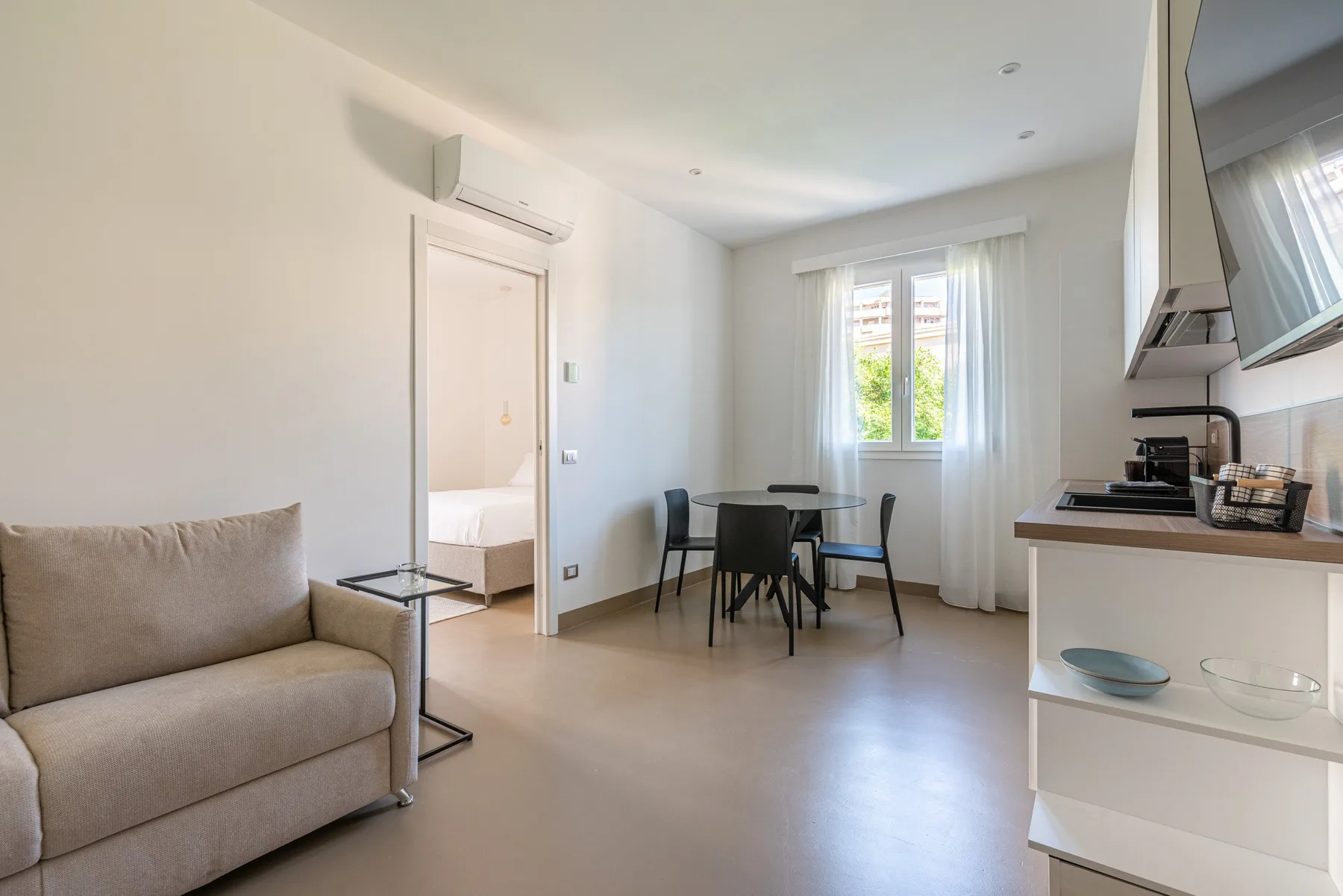Una luminosa sala de estar y comedor con asientos, una mesa y una ventana.