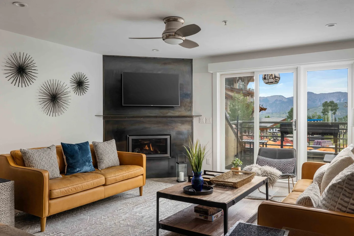 A living room with seating around a coffee table and large windows.