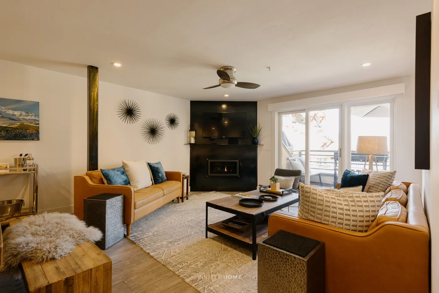 A living room with seating arranged around a coffee table and fireplace.
