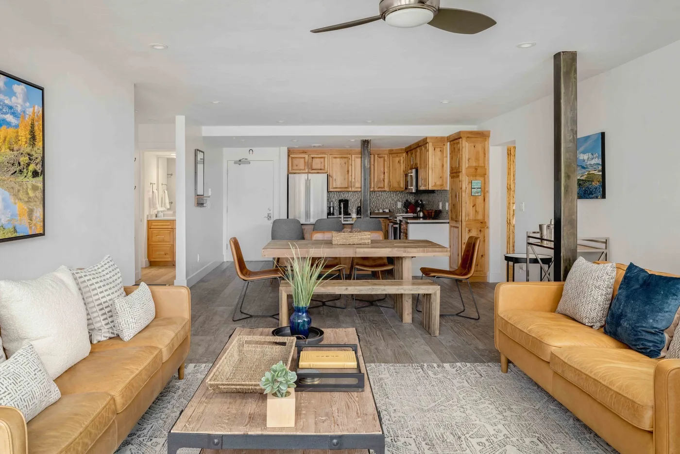 An open-plan living room with seating, a dining table, and a kitchen.