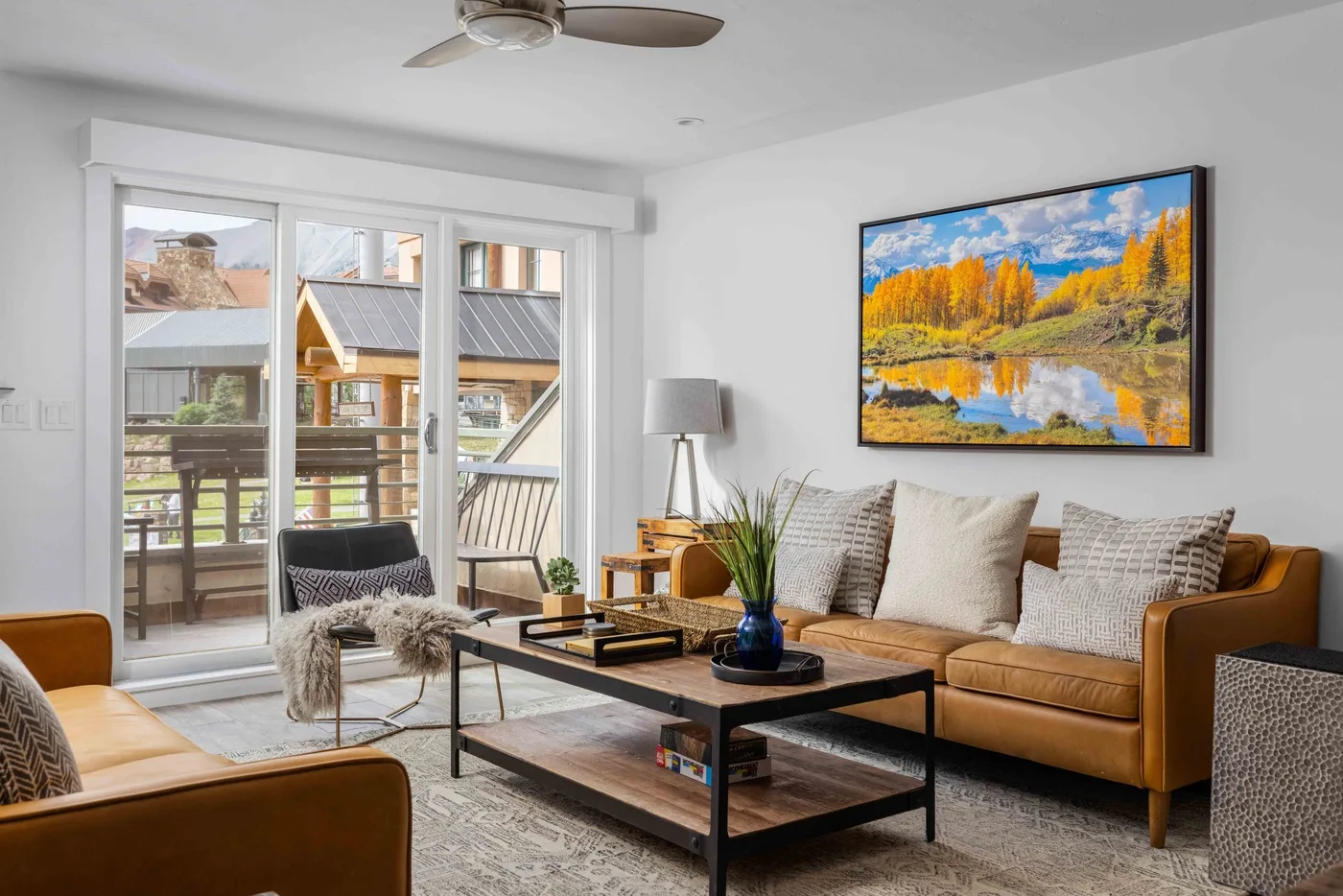 A bright living room with seating, a coffee table, and large glass doors.
