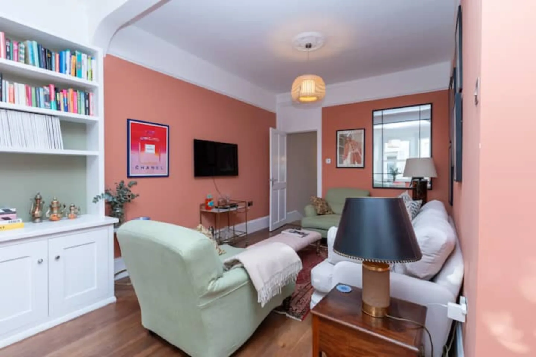 A living room with a television, bookcases, and seating.