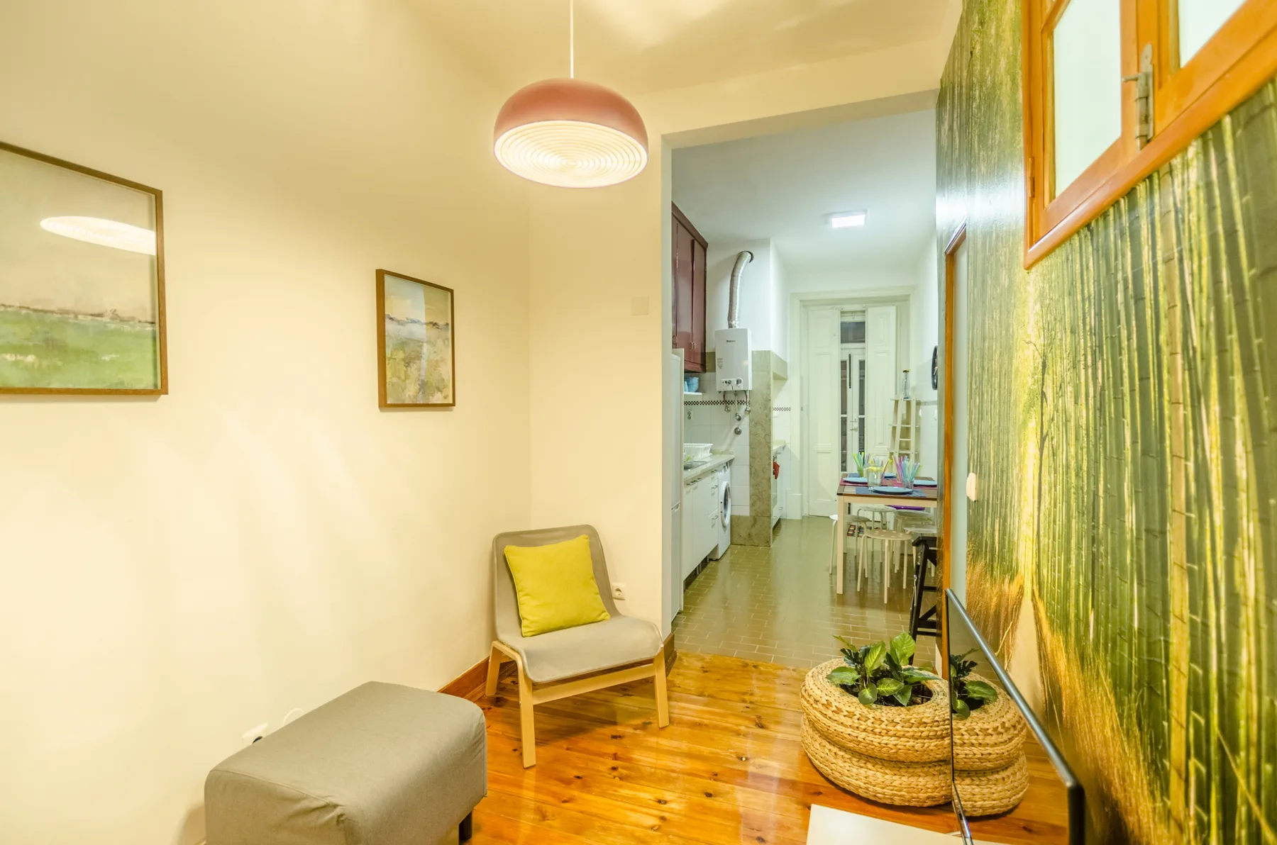 Una luminosa sala de estar con una silla y una vista hacia la cocina y el comedor.