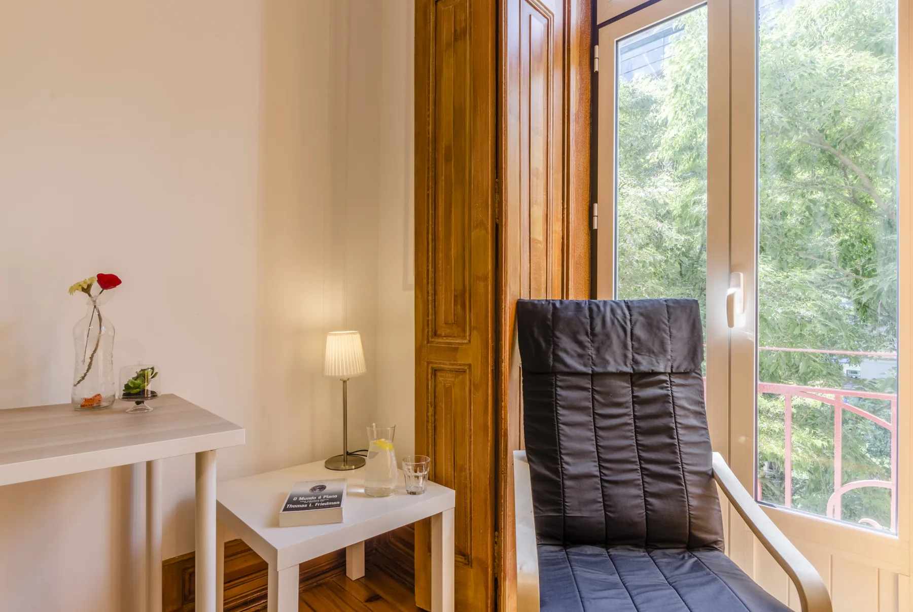 Una zona de estar luminosa con un asiento acolchado junto a una ventana amplia.