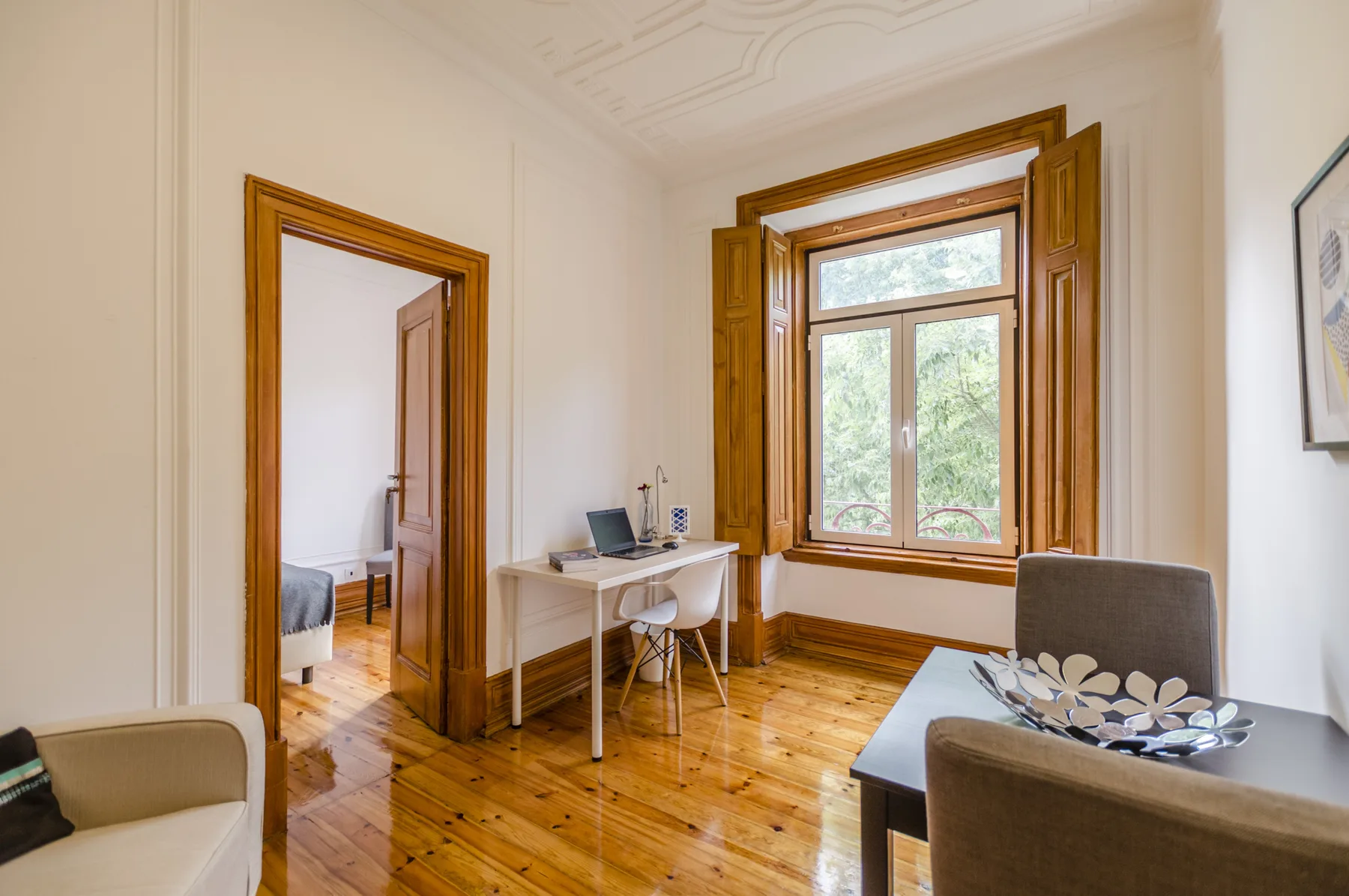 Una sala luminosa con un escritorio junto a una ventana grande.