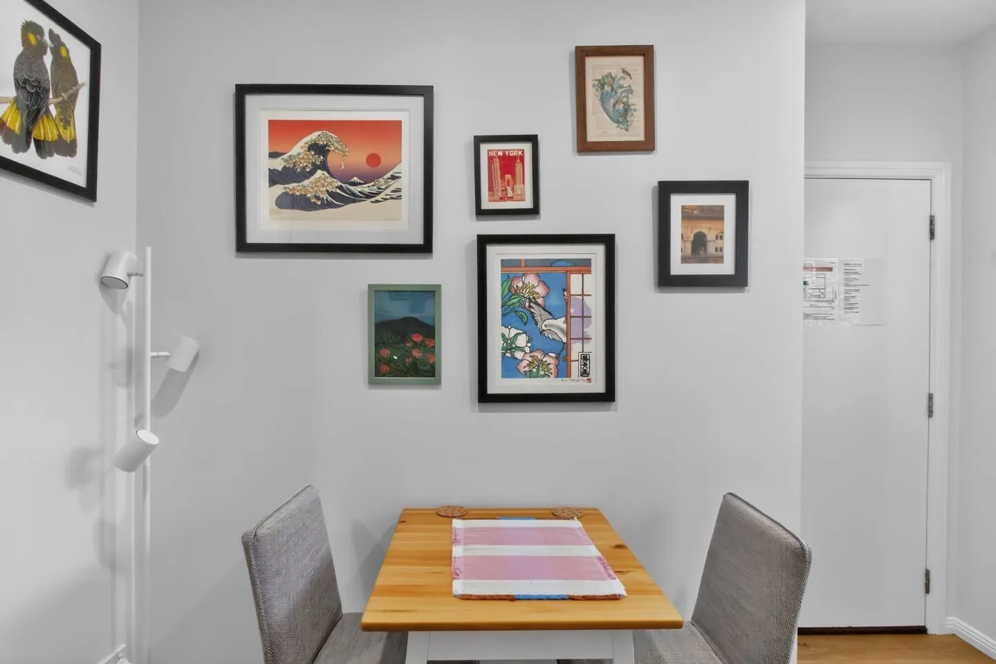 A dining area with framed artwork displayed on the wall.