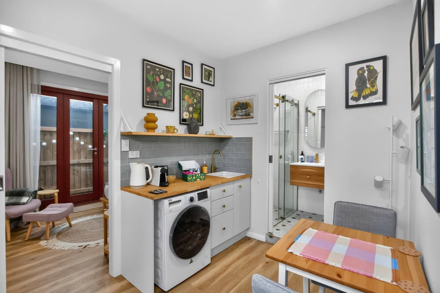 A compact kitchenette with a sink and countertop sits beside a small dining area.