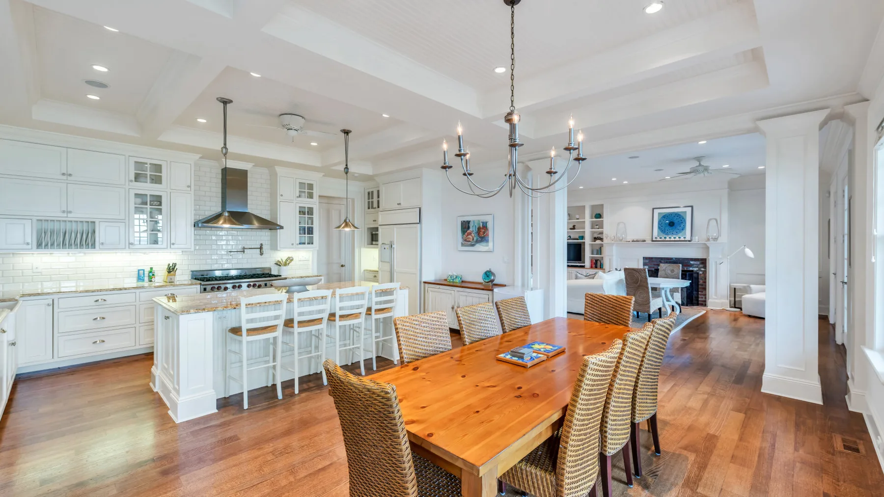 Una cocina abierta y luminosa con comedor y una larga mesa de madera.
