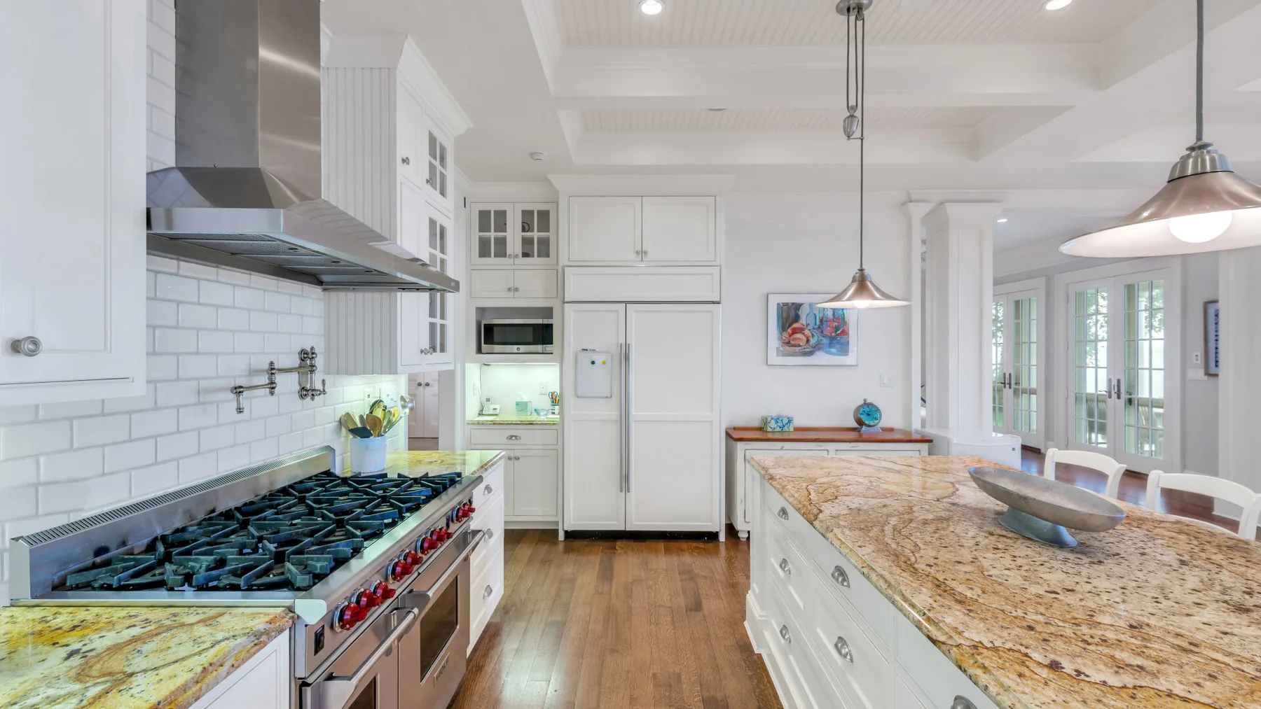 Una cocina luminosa con una isla grande y una estufa junto a la pared.