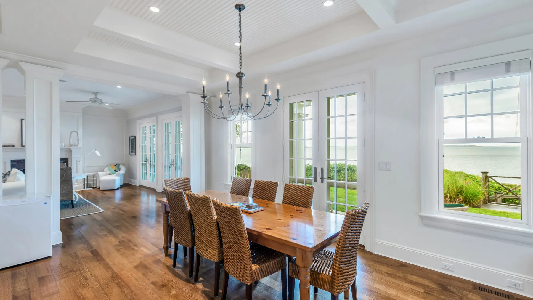 Un comedor luminoso con una mesa de madera junto a grandes ventanas.