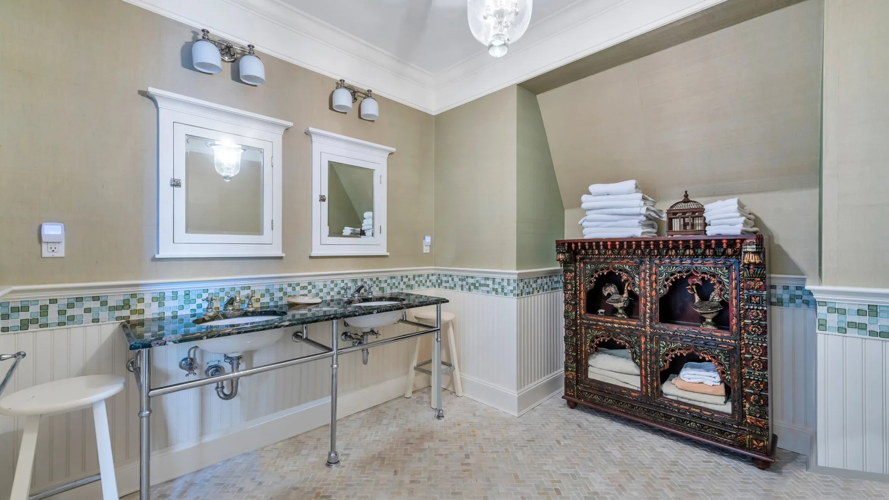 Una zona de lavabo con espejos, lavabos y un salpicadero de azulejos.