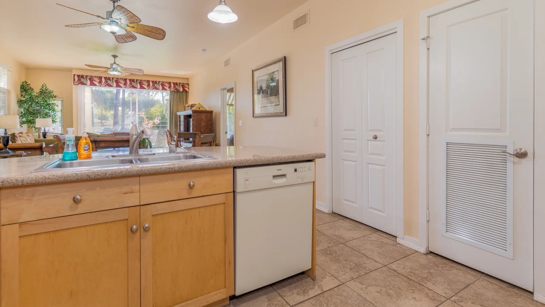 A kitchen with wooden cabinets, a countertop, and a dishwasher.
