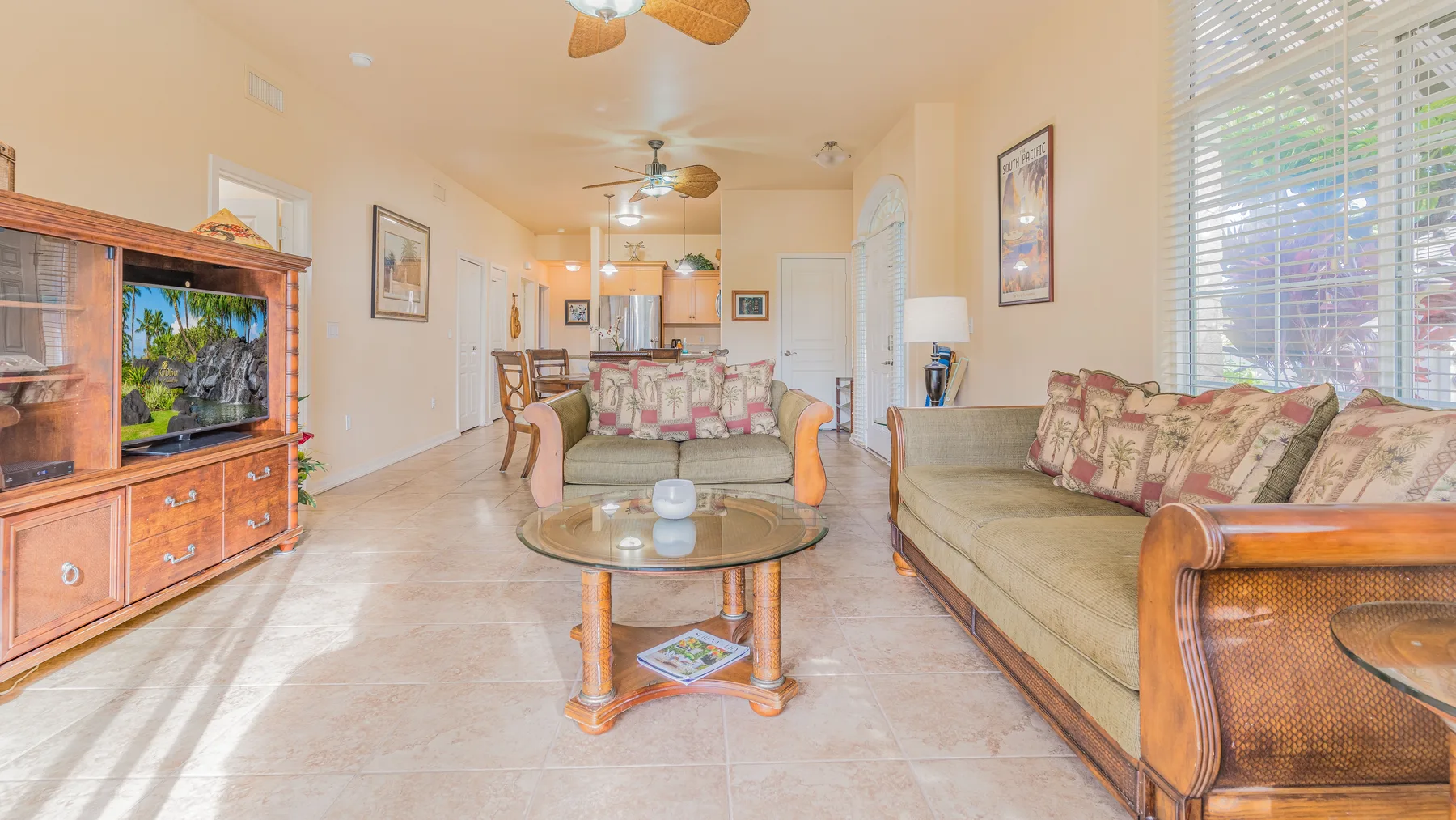 A living room with seating arranged around a coffee table and television.