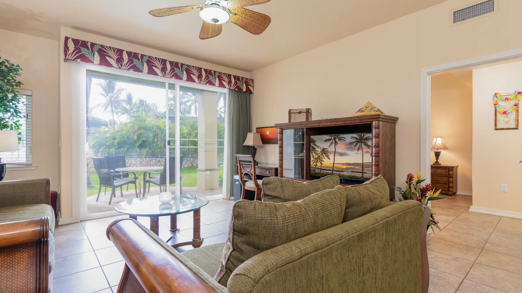 A living room with seating, a coffee table, and sliding glass doors opening to a patio.