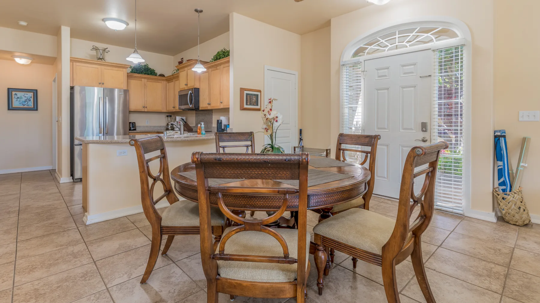 An open dining area with a round wooden table beside the kitchen.