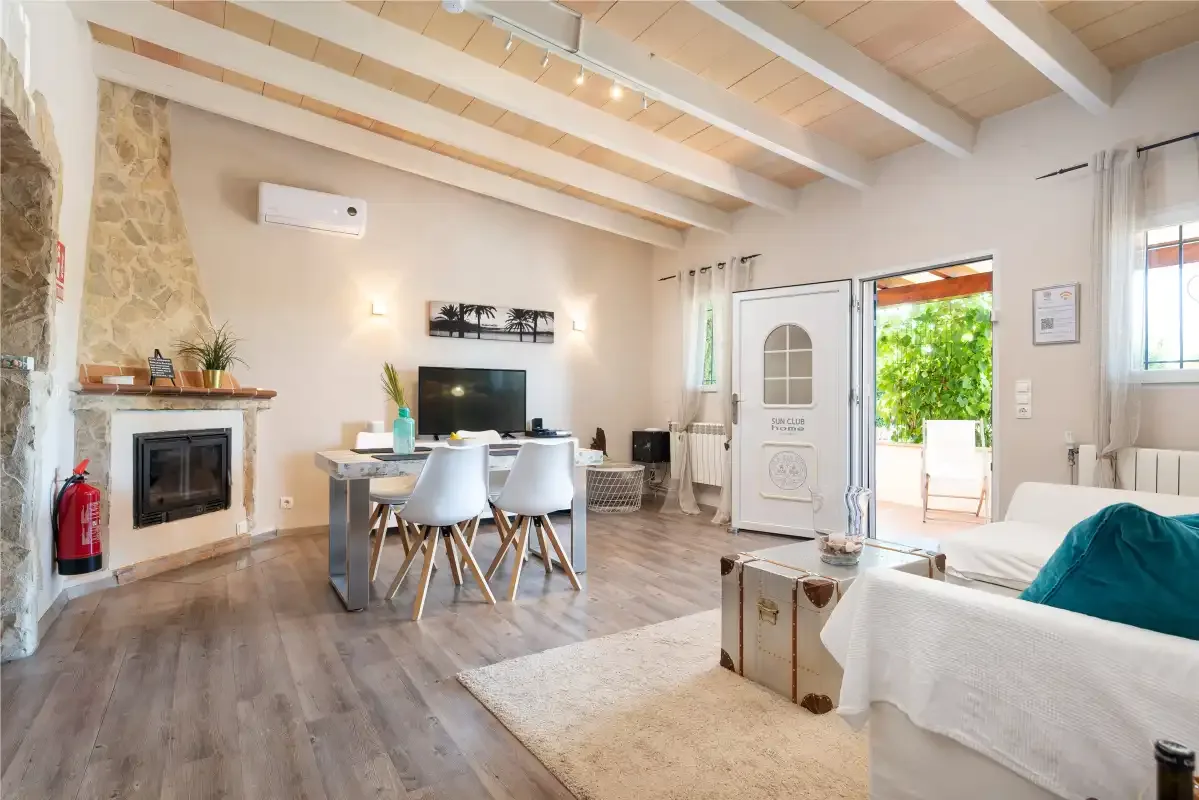 A bright living room with a dining table, fireplace, and seating.