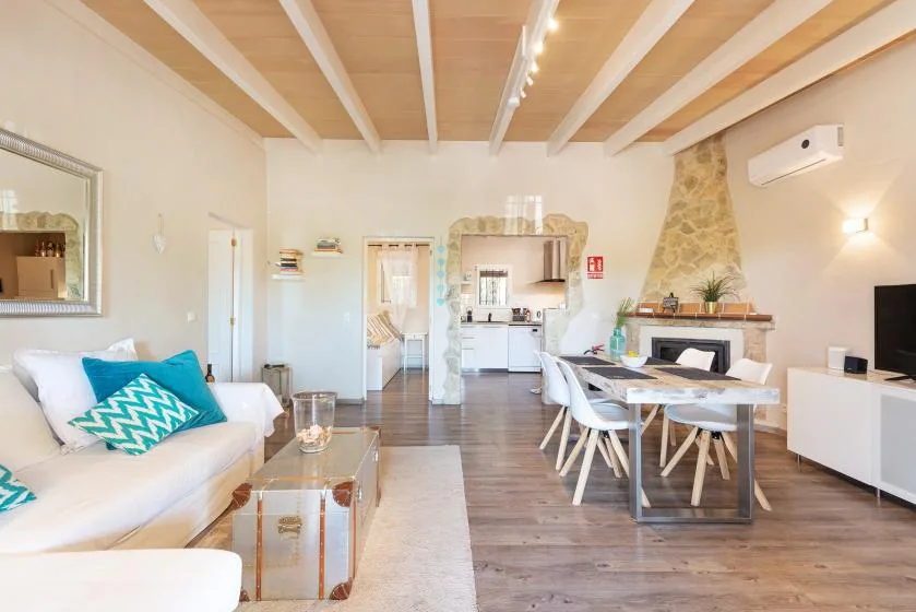 A bright open-plan living and dining area with a kitchen beyond.
