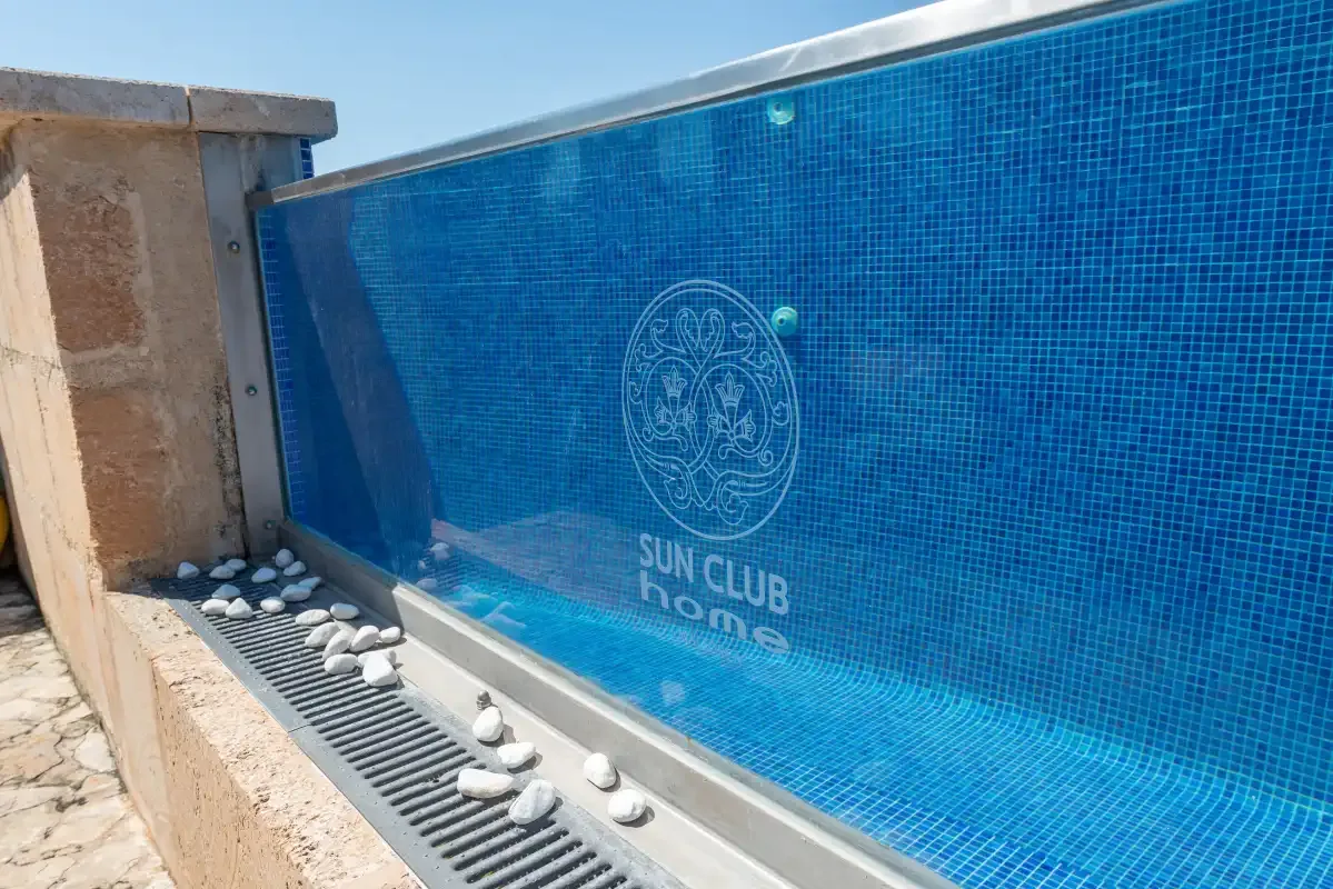 A blue-tiled swimming pool beside a stone-paved edge.
