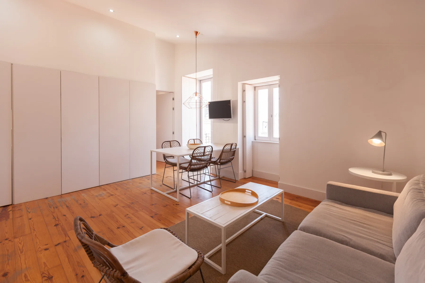 A bright living and dining area with a sofa, table, and chairs.