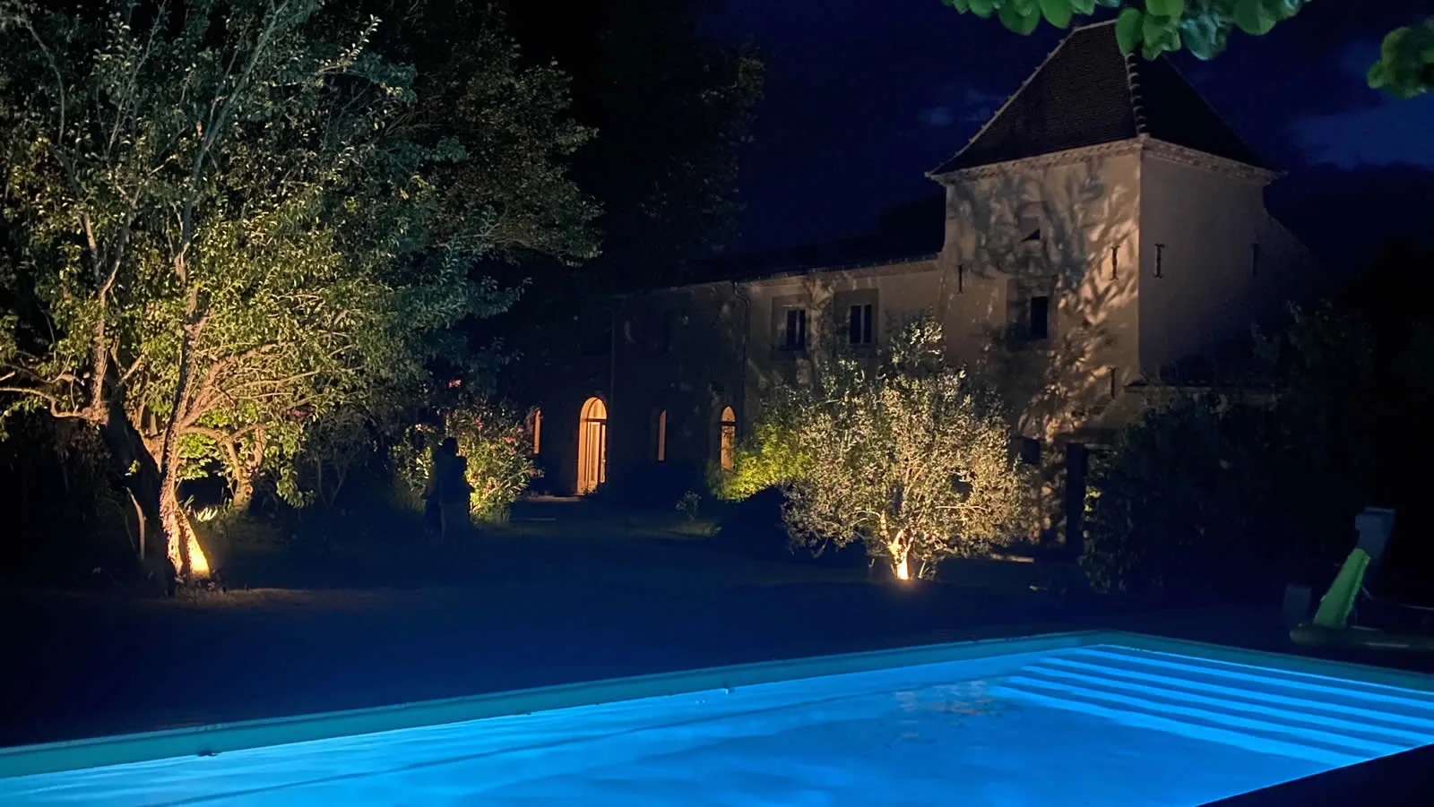 The pool illuminated at night beside the farmhouse