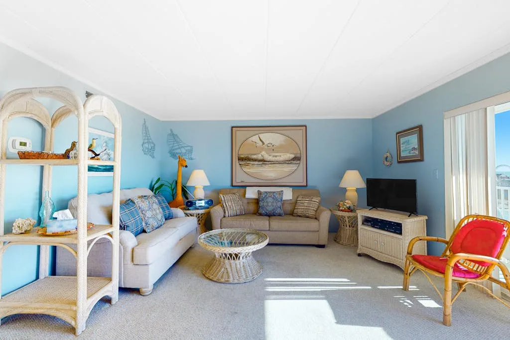 A living room with seating arranged around a coffee table and television.