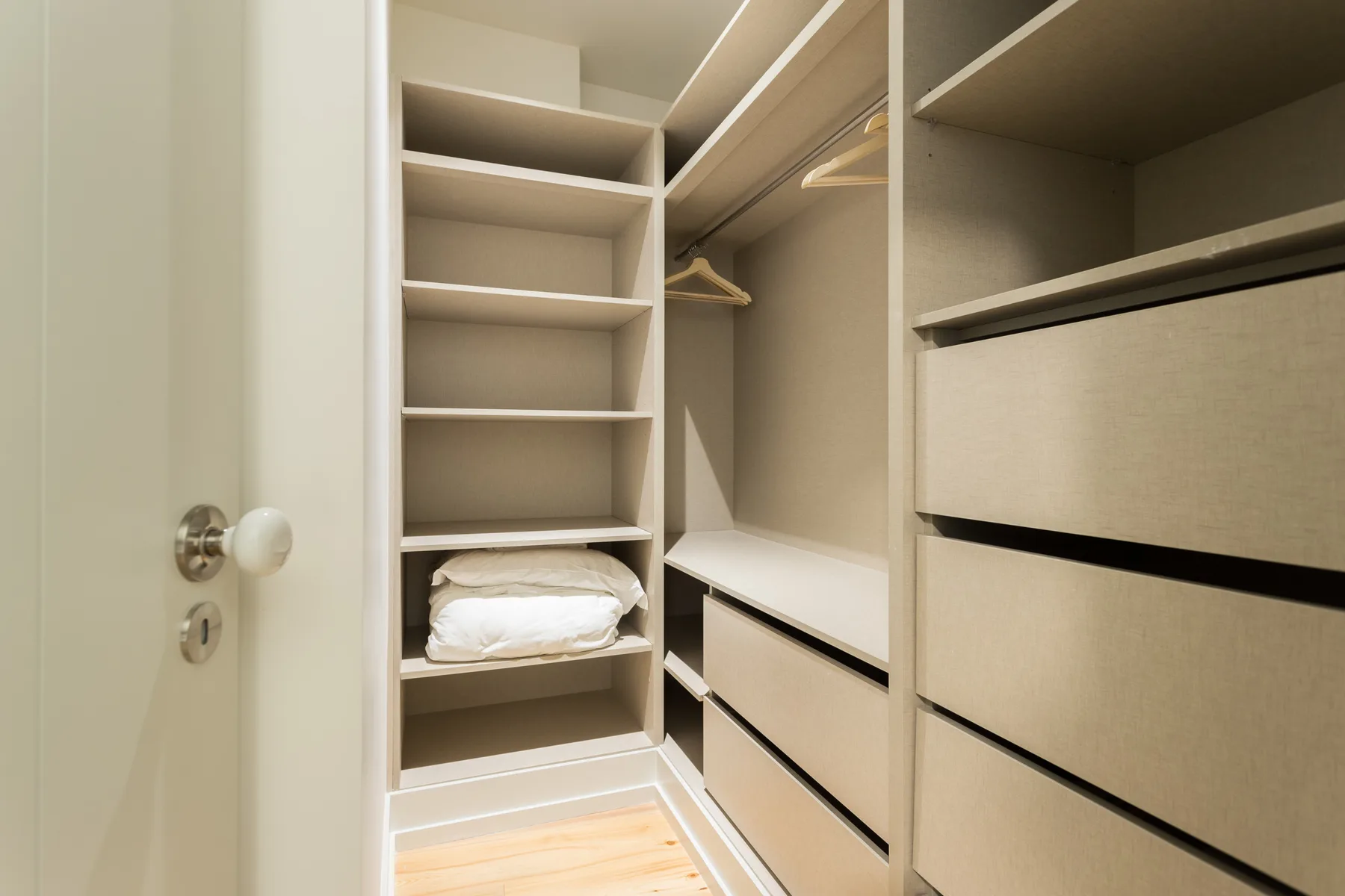 A walk-in closet with open shelving, drawers, and hanging space.