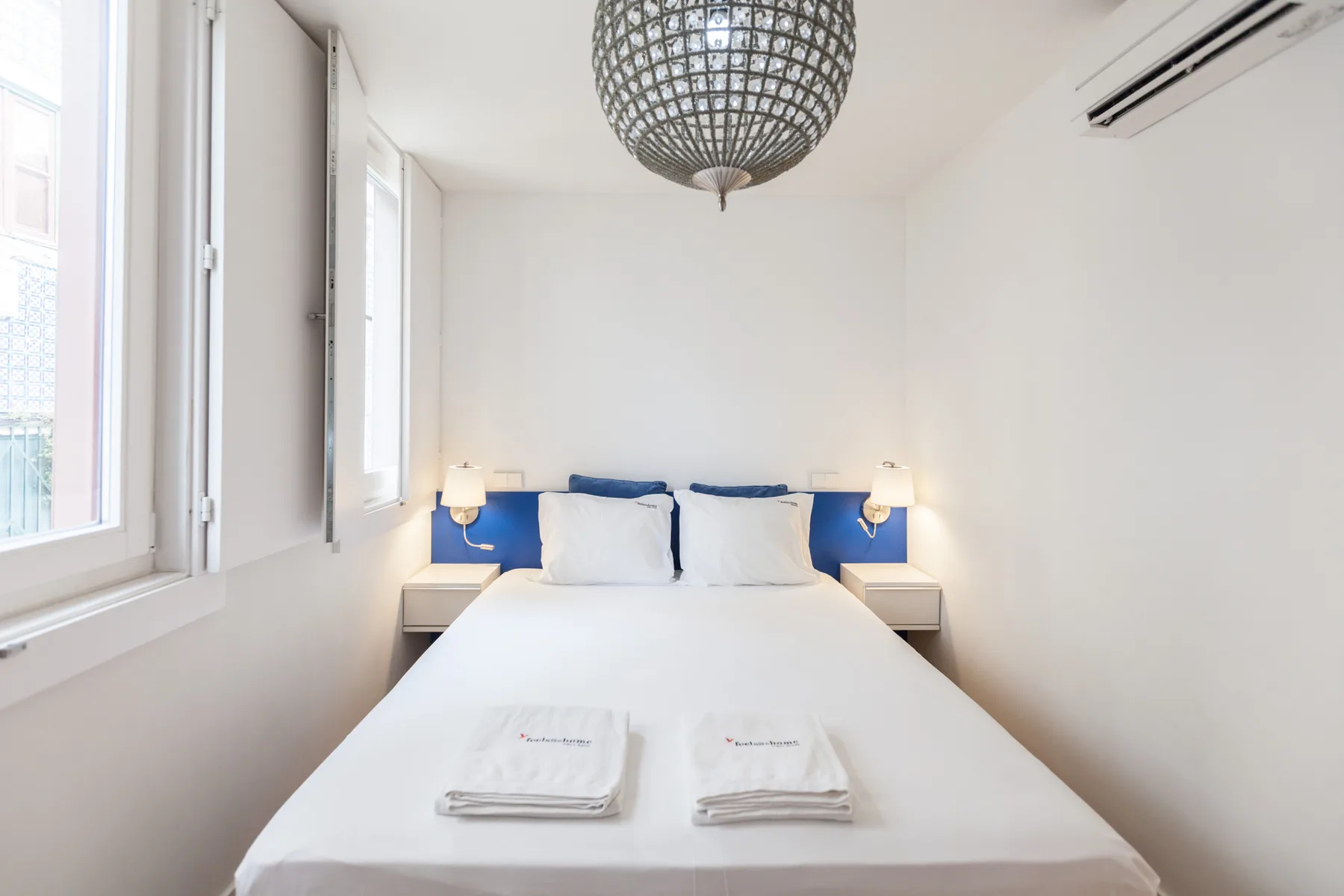 Un dormitorio luminoso con una cama bien hecha y detalles azules.