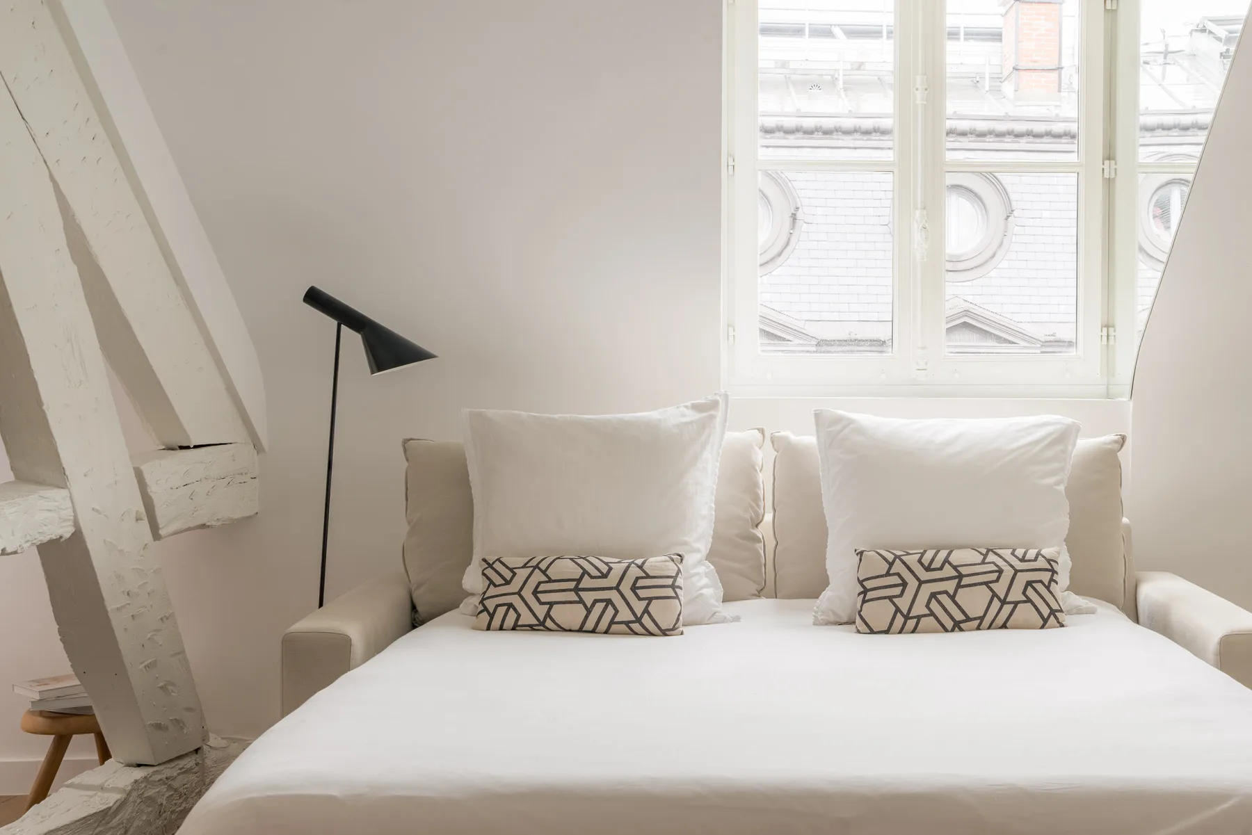 A bright bedroom with a bed and a large window.